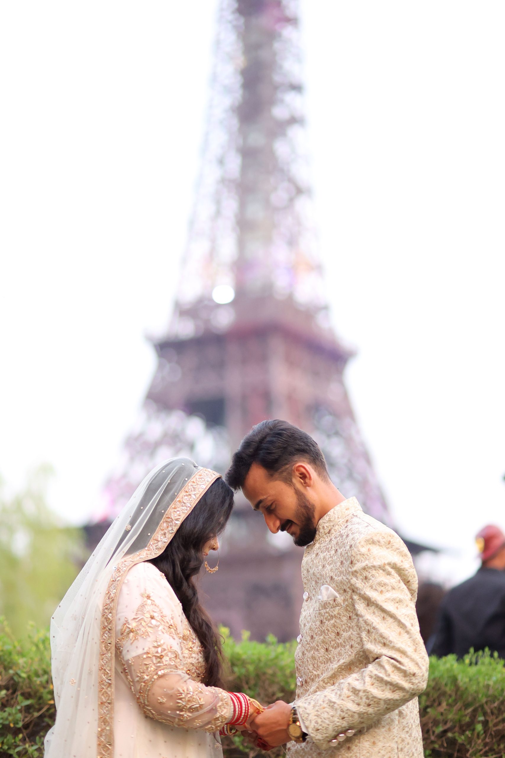 Elegant wedding photo of a couple by Lahore's Eiffel Tower replica, capturing love and tradition.